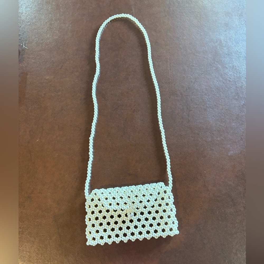 Enjoy this lovely pearl crossbody to carry your cellphone and ID.